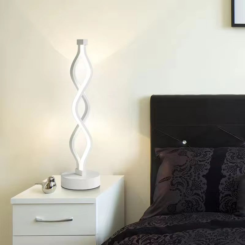 Acrylic LED Desk Lamp lit with white light on a bedside table